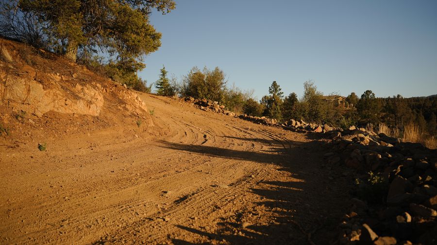 Freshly graded dirt driveway with rock edging in Yavapai County